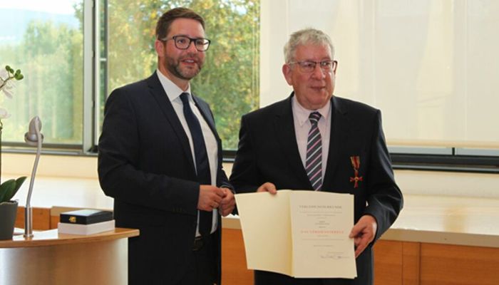Landrat Thorsten Solz überreicht Günter Kauck das Bundesverdienstkreuz am Bande.